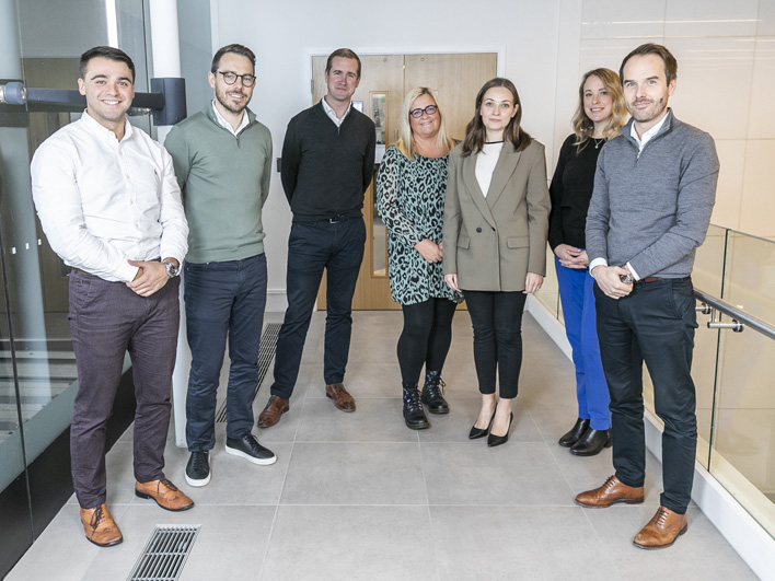 Six professionals, three men and three women, standing confidently in an office corridor at LDC Yorkshire, dressed in smart casual attire.